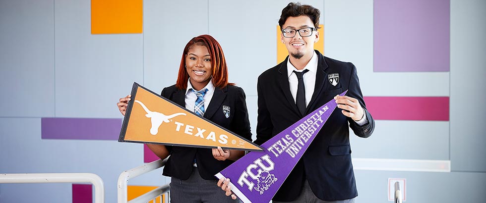 Two high school students holding college pennants